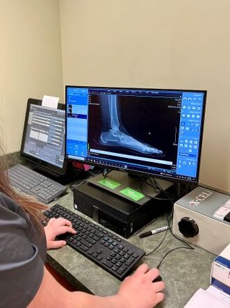 Clover Podiatry technician looking at an X-ray of foot